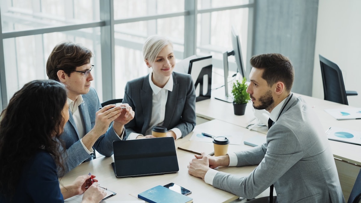 A small professional team collaborating around a table in a bright modern office
